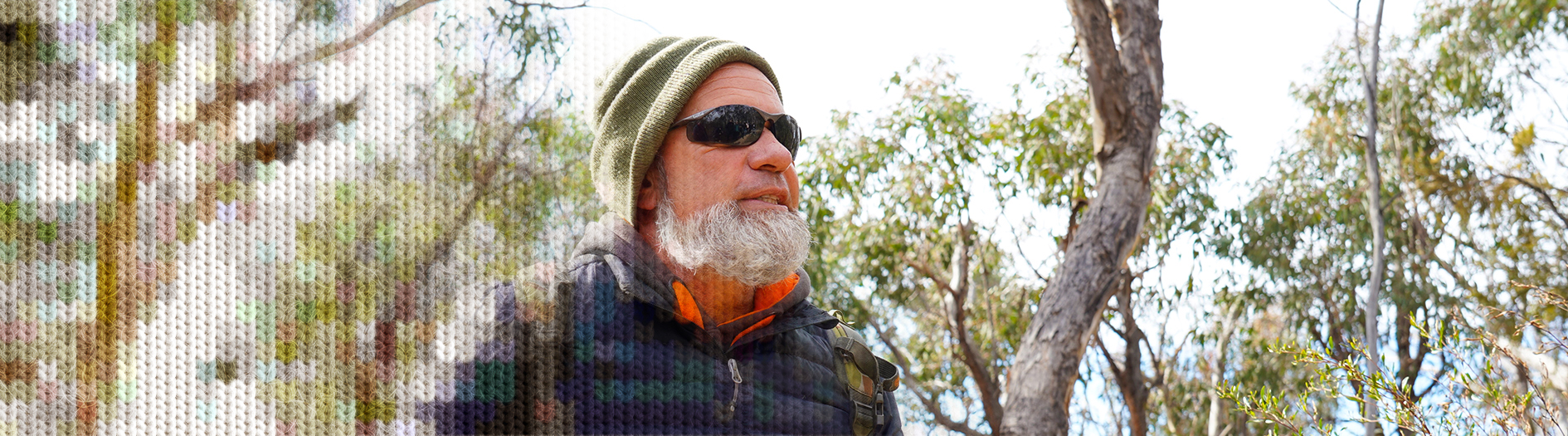 Indigenious man Tyronne Bell looks to the distance in a forest. A knit effect has been applied to the image for a wintery effect