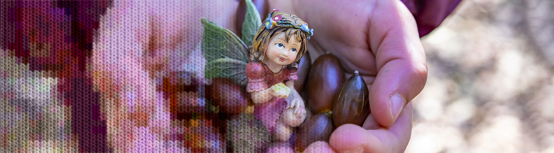 A childs hands hold a collection of large seeds and a fairy figurine
