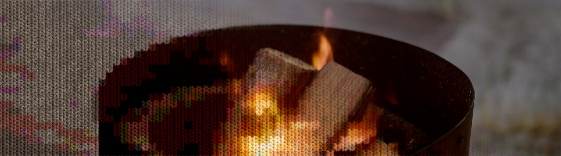 A wood fire burns brightly in a cylindrical metal firepit