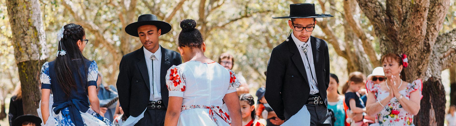 dancers in traditional cultural wear performing in the cork oak forest