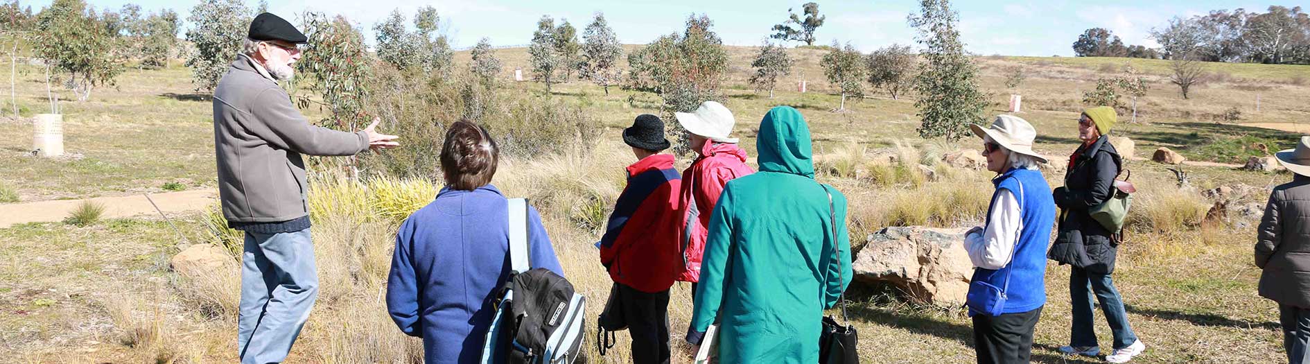 group wearing hats listening to male guide present tour