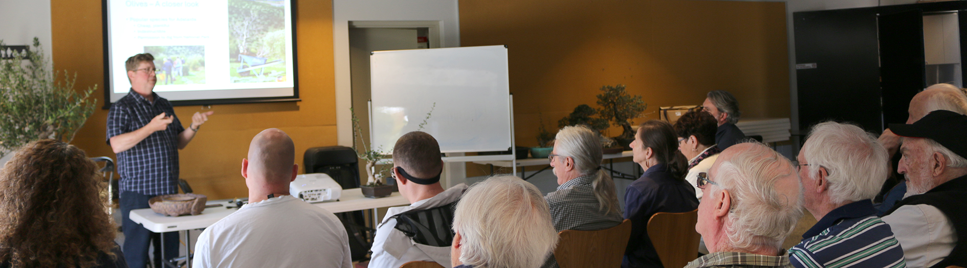 Photo taken from behind the volunteers all seated listening to Matt's presentation.
