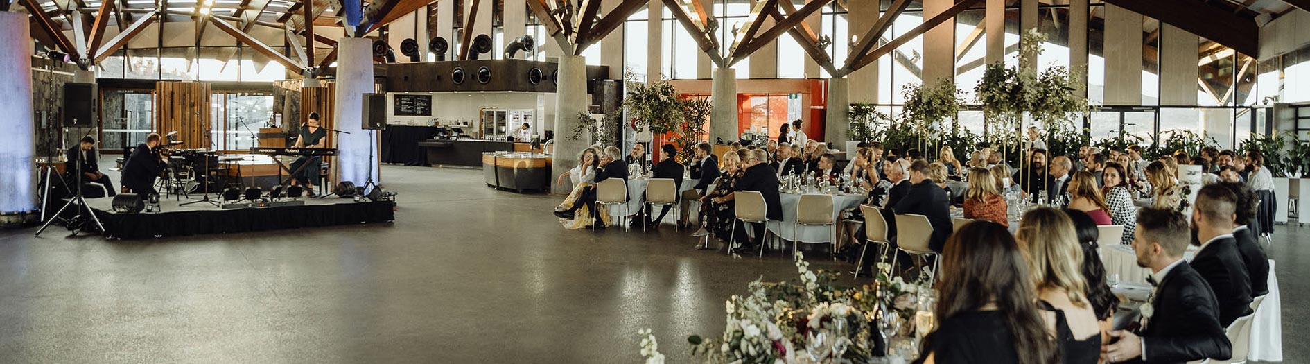 View of a wedding band and guests seated at tables in the village centre.