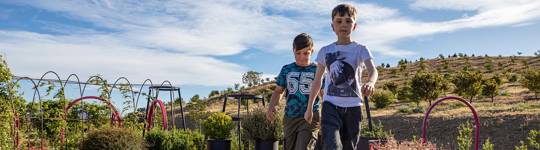 To young boys smiling at camera with green forests visible in the background