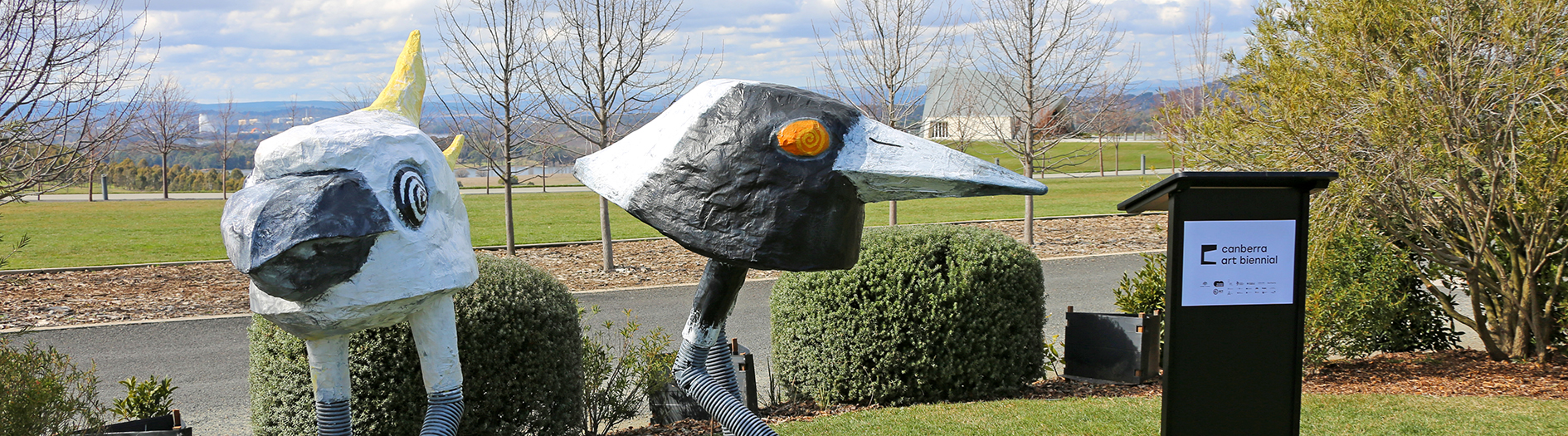 Large sculptures of a Cockatoo and Magpie next to lectern