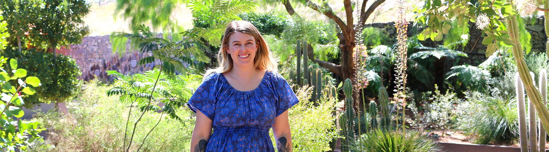 Amalie Shawcross photogrpahed in the Discovery Garden, smiling, facing the camera