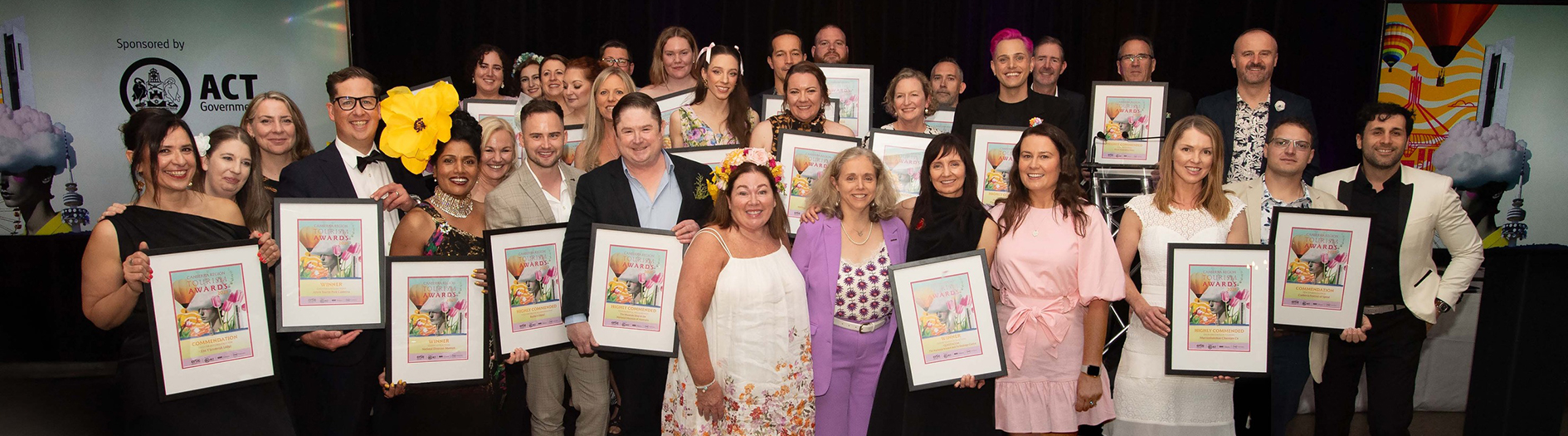 Award recipients hold their awards together at the Canberra Region Tourism Awards night.   