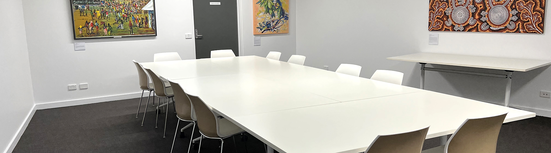 White meeting room with large white conference table