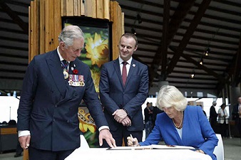 Charles and Camila signing visitors book with Andrew Barr