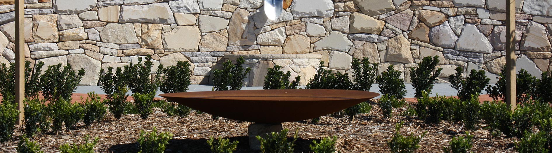 metal sclpture with newly planted hedge in the background