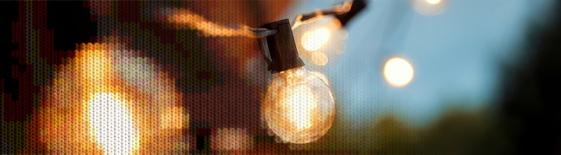 A string of festoon lightbulbs glow yellow against a dark twilight sky